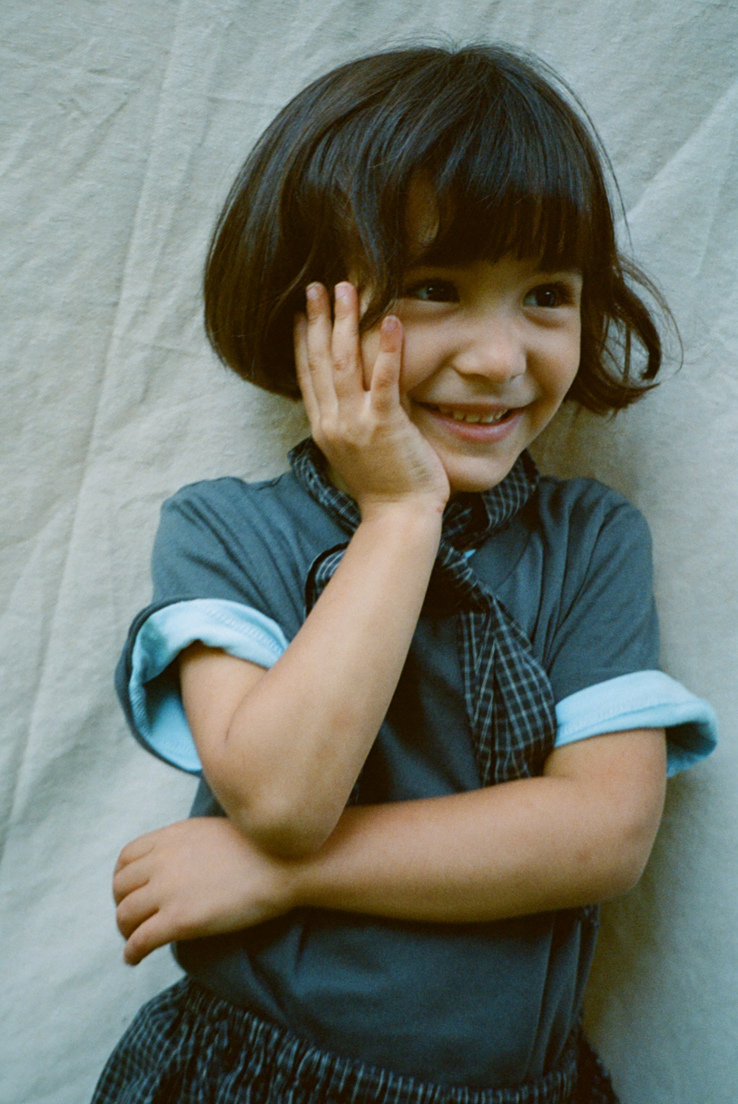 Young girl with a happy expression against a textured light gray background
