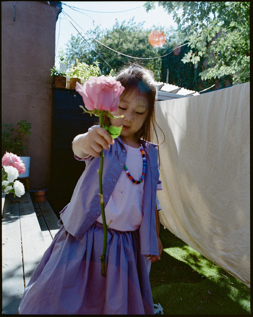 Young boy wearing a purple shirt standing outdoors with a natural background